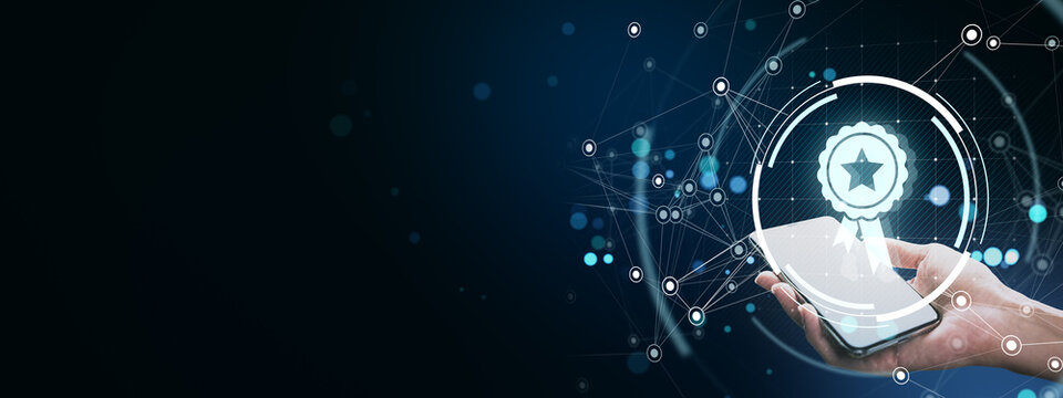 Businessperson holding smartphone with virtual award icon and digital network connections on dark futuristic background concept of recognition.