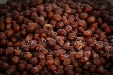 A detailed view of a bowl filled with dried brown peas, showcasing their rough texture and earthy color tones, ideal for natural food and agriculture visuals.