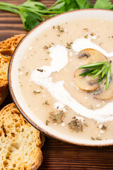 Delicious and healthy mushroom soup on wooden background