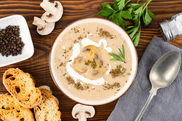 Delicious and healthy mushroom soup on wooden background