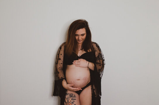 Femme enceinte en sous v&ecirc;tement noir sur fond blanc