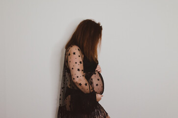 Femme enceinte en sous vêtement noir sur fond blanc