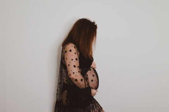 Femme enceinte en sous v&ecirc;tement noir sur fond blanc