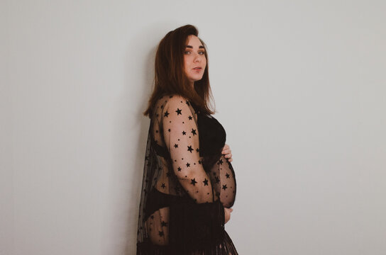 Femme enceinte en sous v&ecirc;tement noir sur fond blanc