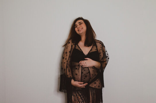 Femme enceinte en sous v&ecirc;tement noir sur fond blanc
