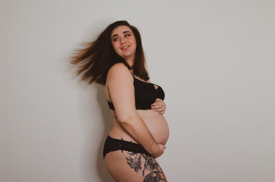 Femme enceinte en sous v&ecirc;tement noir sur fond blanc