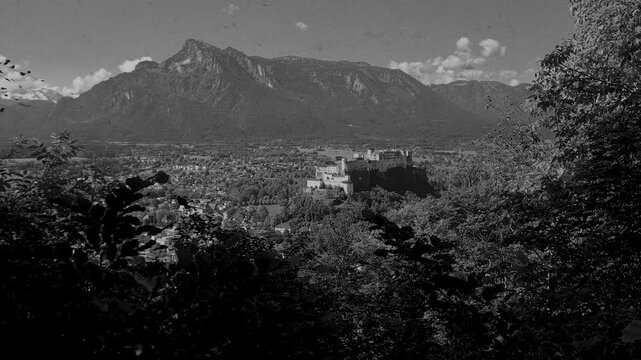 Vintage film-stylised black and white Video of Salzburg city in Austria. Castle with the mountains on the background. 