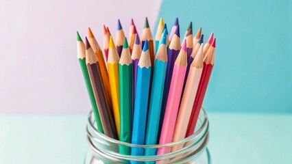 Fototapeta premium Close-up view of colored pencils in a glass jar, highlighting the sharp tips and the range of colors, perfect for themes of art materials and creative work. 