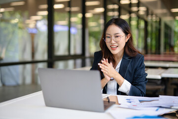 Asian woman laughing while talking on the phone in the office © maeching