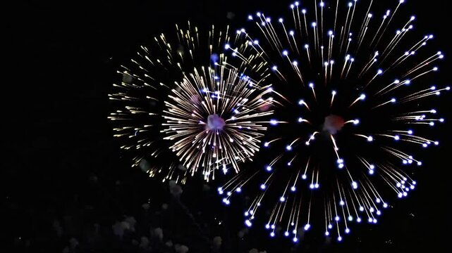 Vibrant display of colorful fireworks exploding in the night sky during a celebration, creating a spectacular view. Ideal for a celebratory video, 4th of July, New Year, Independence Day
