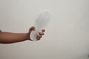 A hand holding slippers. Hitting gestures. Isolated on white