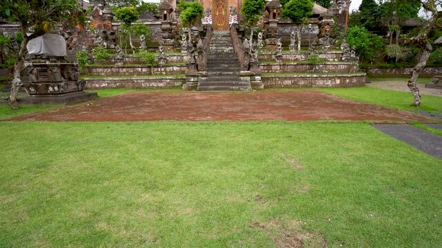 Grand Balinese temple entrance with ornate gate featuring demon mask and ceremonial stairwayMagnificent temple portal displaying intricate stone carvings and traditional Indonesian architecture