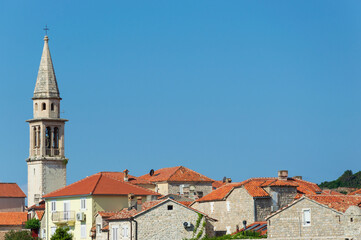 Fototapeta premium View of the old historic town with church, tiled roofs, general plan against the blue sky