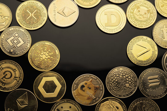 Collectible Coins Representing Various Cryptocurrencies on a Reflective Surface
