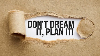 Beige textured paper with torn edges revealing text: Don't dream it, plan it!  Motivational concept, emphasizing action over fantasy
