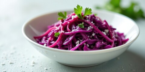 A vibrant purple cabbage salad, delicately shredded and seasoned, artfully arranged in a pristine white bowl, garnished with fresh parsley and a sprinkle of seasoning, ready to be enjoyed.