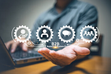A business professional demonstrates B2B concepts using digital icons and a laptop, emphasizing communication, teamwork, and networking.