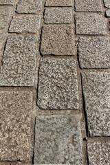 Texture of square paving tile. Pattern of gray sidewalk tiles in the street. Concrete pavers close up background.