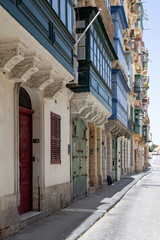 Old houses in Valletta city, island of Malta, with traditional bay windows and colourful shutters and doors.