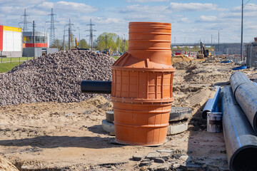 Plastic sewer inspection chamber and drainage pipes at a construction site for underground...