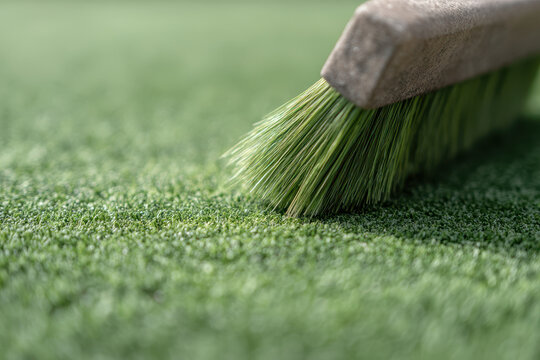 Close up of brush on artificial grass, showing texture and detail