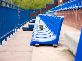 A blue stadium with empty seats and a cup on one of them