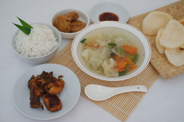 A Delicious Indonesian Meal with Rice, Chicken, Soup and Crackers