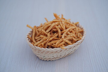 Pile of Crispy Fried Snack Sticks in a Woven Basket