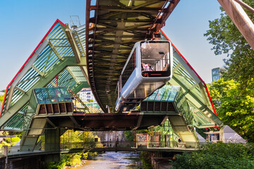 Eine Schwebebahn fährt aus der Haltestelle Kluse, Wuppertal, Deutschland