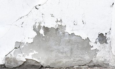 Weathered shebby concrete wall with a big hole and many cracks