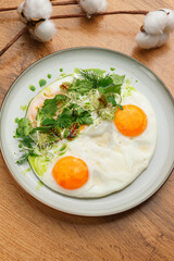 Fried Eggs with Microgreens on White Plate