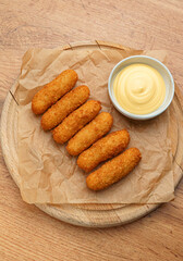 Cheese sticks on paper with mayo