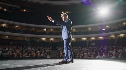 Charismatic speaker engages enthusiastic audience in captivating theater presentation