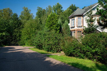 Residential house near forest with asphalt road.