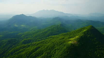 Stunning aerial view of lush green mountains with rolling hills under a serene sky.