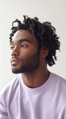 Obraz premium Thoughtful young man in casual lavender hoodie looking away in soft natural light
