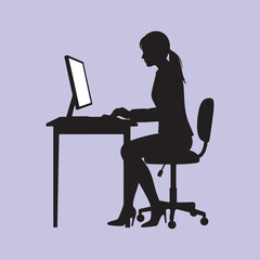 silhouette of a career woman working at a computer