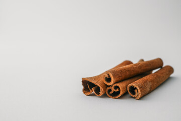 Cinnamon sticks arranged on a white background in soft natural light, showcasing texture and spice...