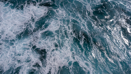 ocean surface foaming from waves, texture and shape of sea water, aerial view