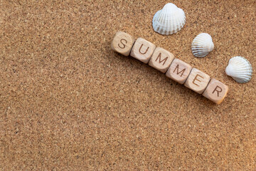 Summer theme. Wooden blocks spelling summer and seashells on cork background