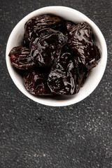 Prunes dried fruit smoked plum snack fresh delicious gourmet food background on the table rustic food top view copy space keto and paleo diet vegetarian and vegan food