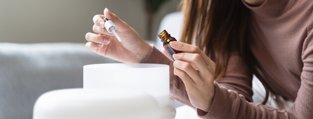 Women drop essential oil into the humidifier to make aromatherapy refreshments atmosphere house for...