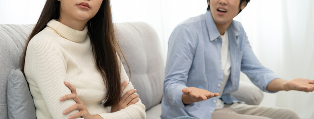 Obraz premium Family problems, Asian women cover her face and sit separately from husband feel disappointed after quarrels at home.