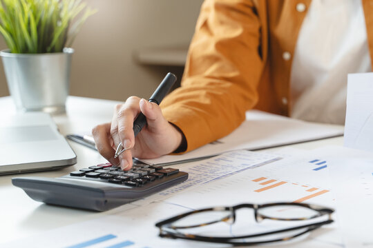 person using calculator calculating tax refund on the table