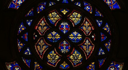 Ornate Symmetry Stained Glass Window Piece - A circular stained glass window showcasing intricate symmetrical patterns in blue, red, and gold. The design symbolizes faith, artistry, history, light