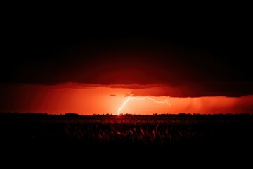 Stormy sunset over field