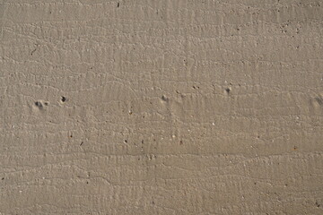 Textured sandy surface with natural patterns and small imperfections in a neutral color palette