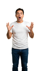 Naklejka premium A surprised man in casual clothing shows shock with raised hands and open mouth.