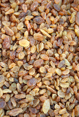 Close-up of dried grapes background. Raisins background. Yellow raisins close-up. Brown raisin texture.