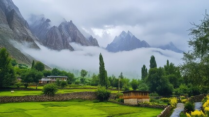 Fototapeta premium Serene Mountain Landscape with Lush Green Fields and Fog